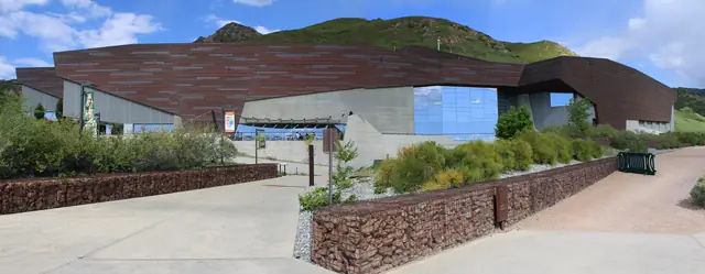 The copper-clad Rio Tinto Center, home of the Natural History Museum of Utah, set against green foothills