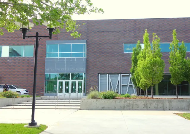 Brick and glass entrance of the Marcia and John Price Museum Building with the UMFA letters out front
